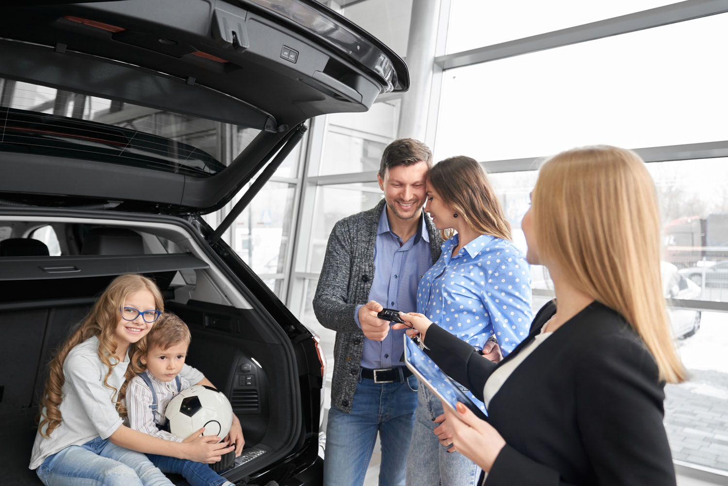 A family receiving their car keys from a salesperson