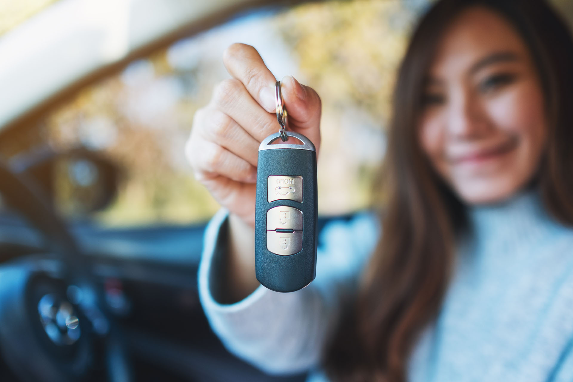 A woman holding the keys to the used car she just purchased