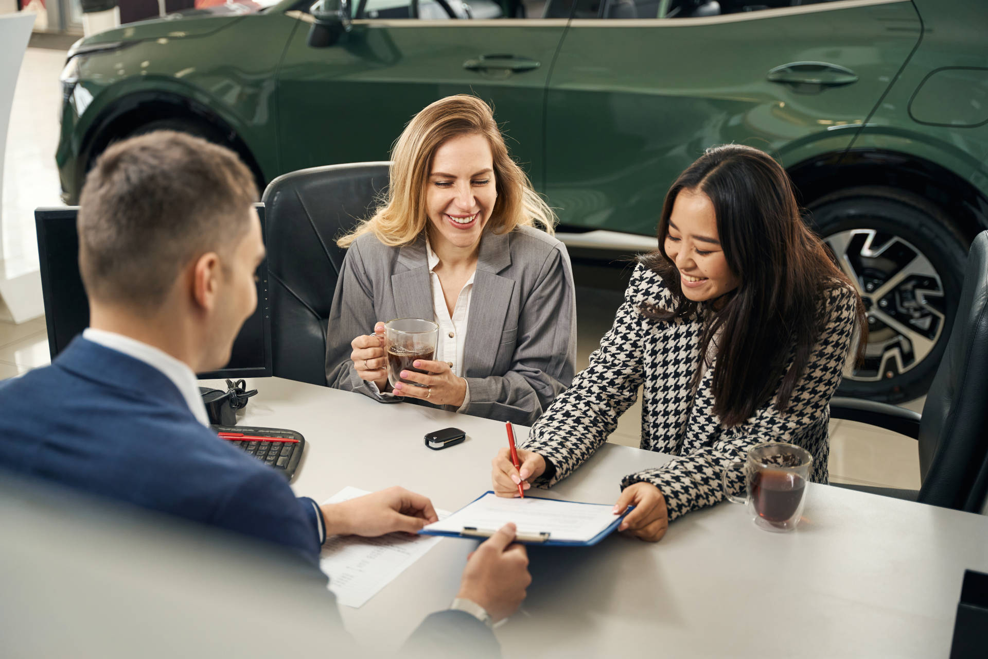 A smiling woman signing for her car loan