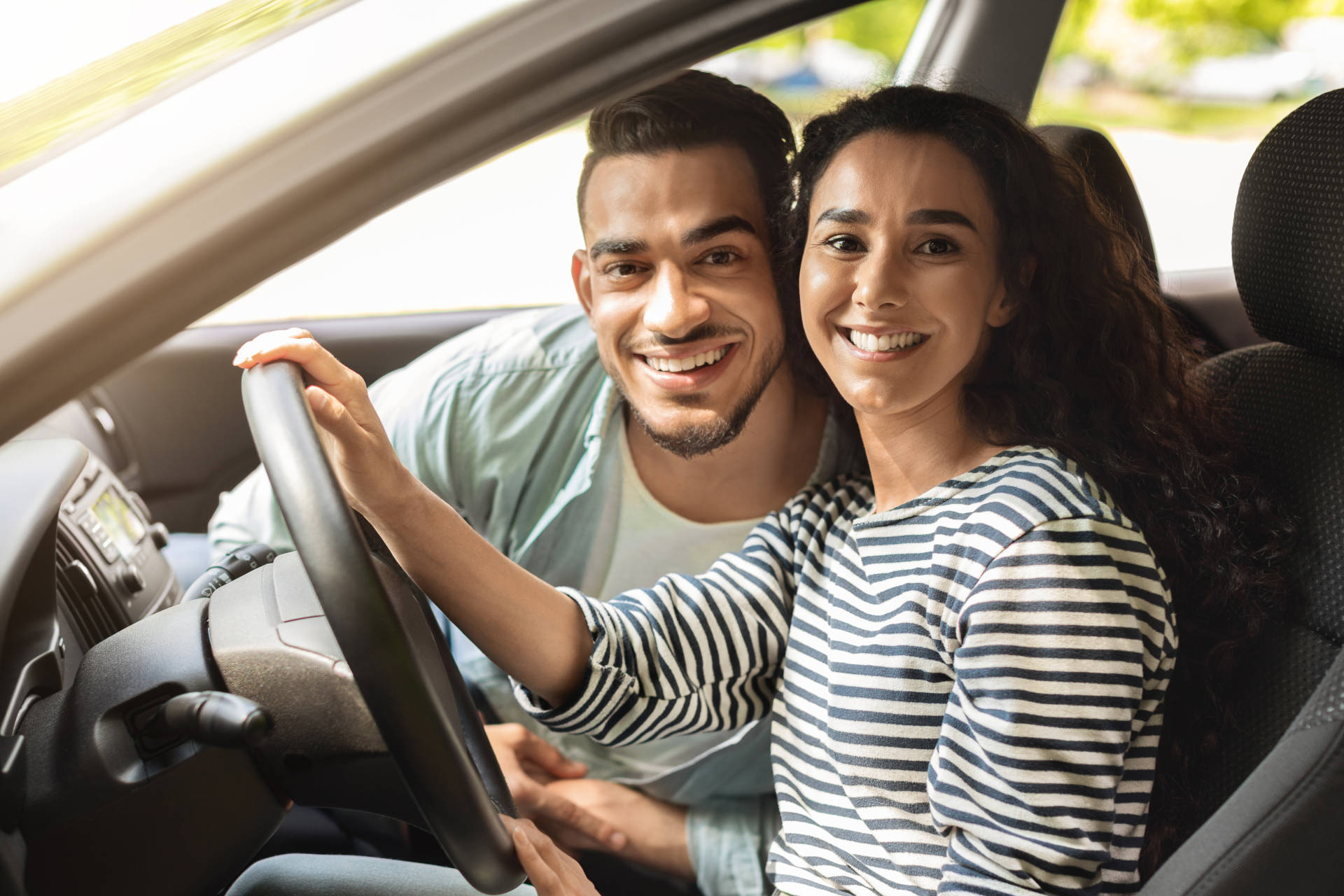 A smiling young couple sitting in a car