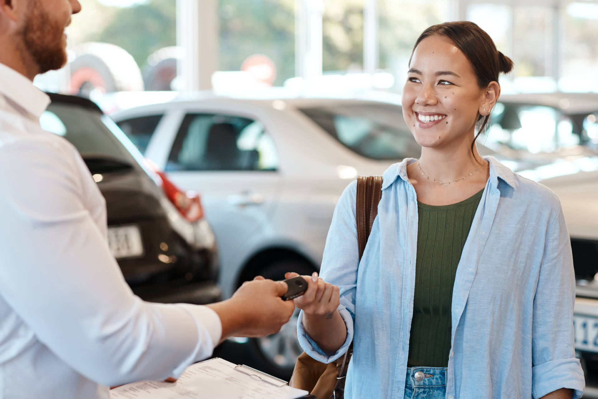 A woman receives the keys to her used car