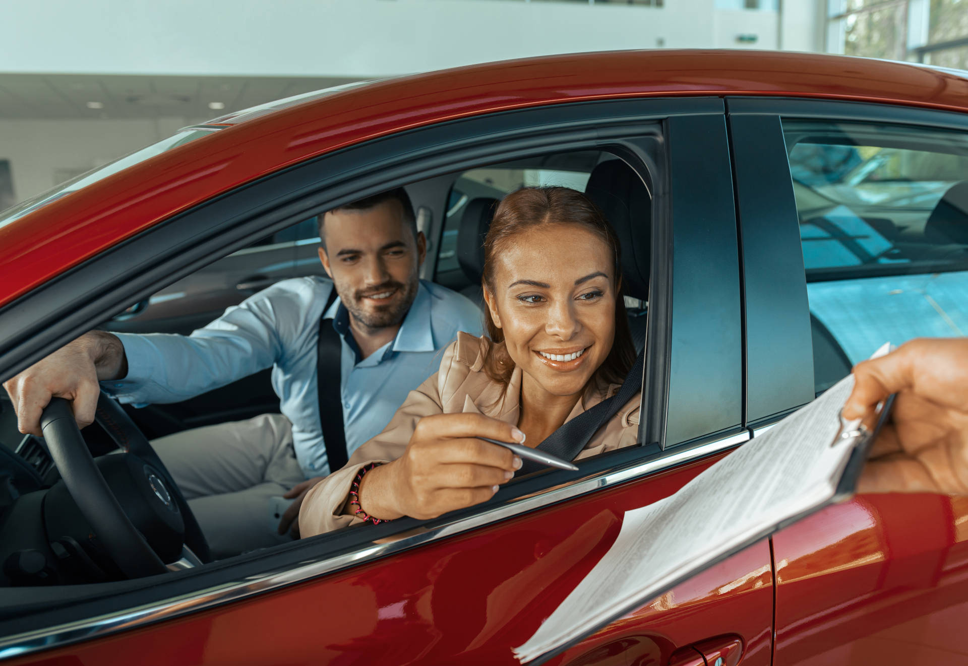 A couple signing for thier used car